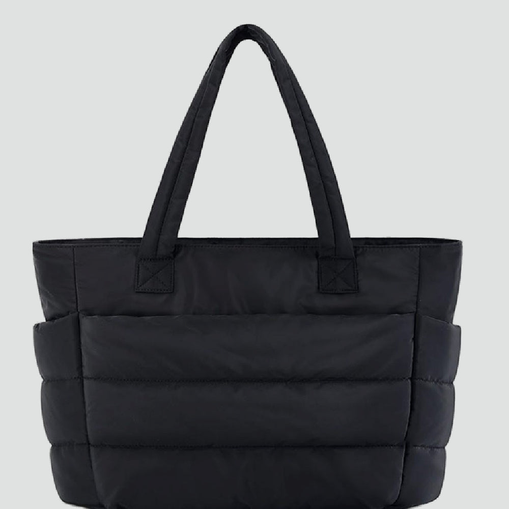 De Cloud Tote, een zachte, gewatteerde tas in trendy kleuren zoals zwart, roze en beige, perfect voor werk, school, of een dagje uit.