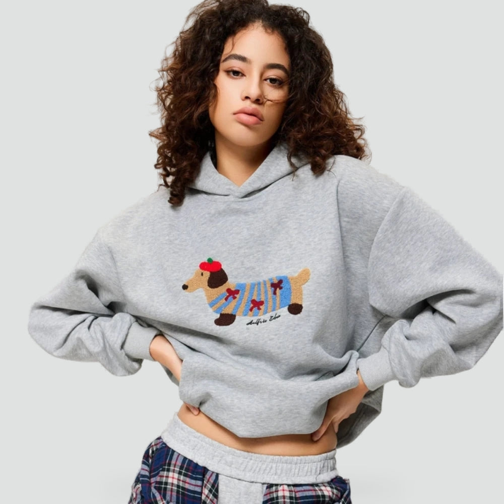 Cozy Pup Hoodie met geborduurde teckel in een kleurrijke trui, perfect voor koude winterdagen en feestelijke momenten